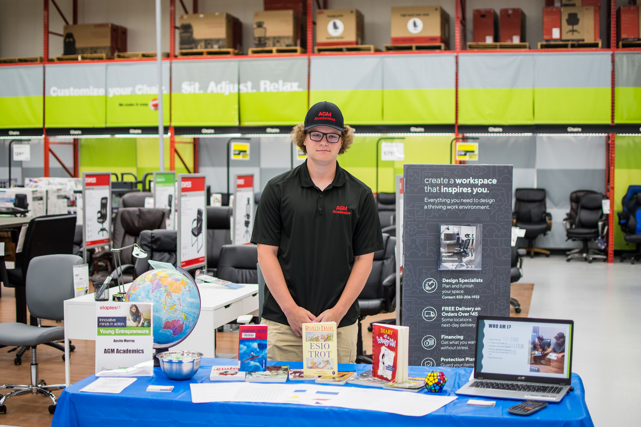 Young man standing behind his booth at Staples Day