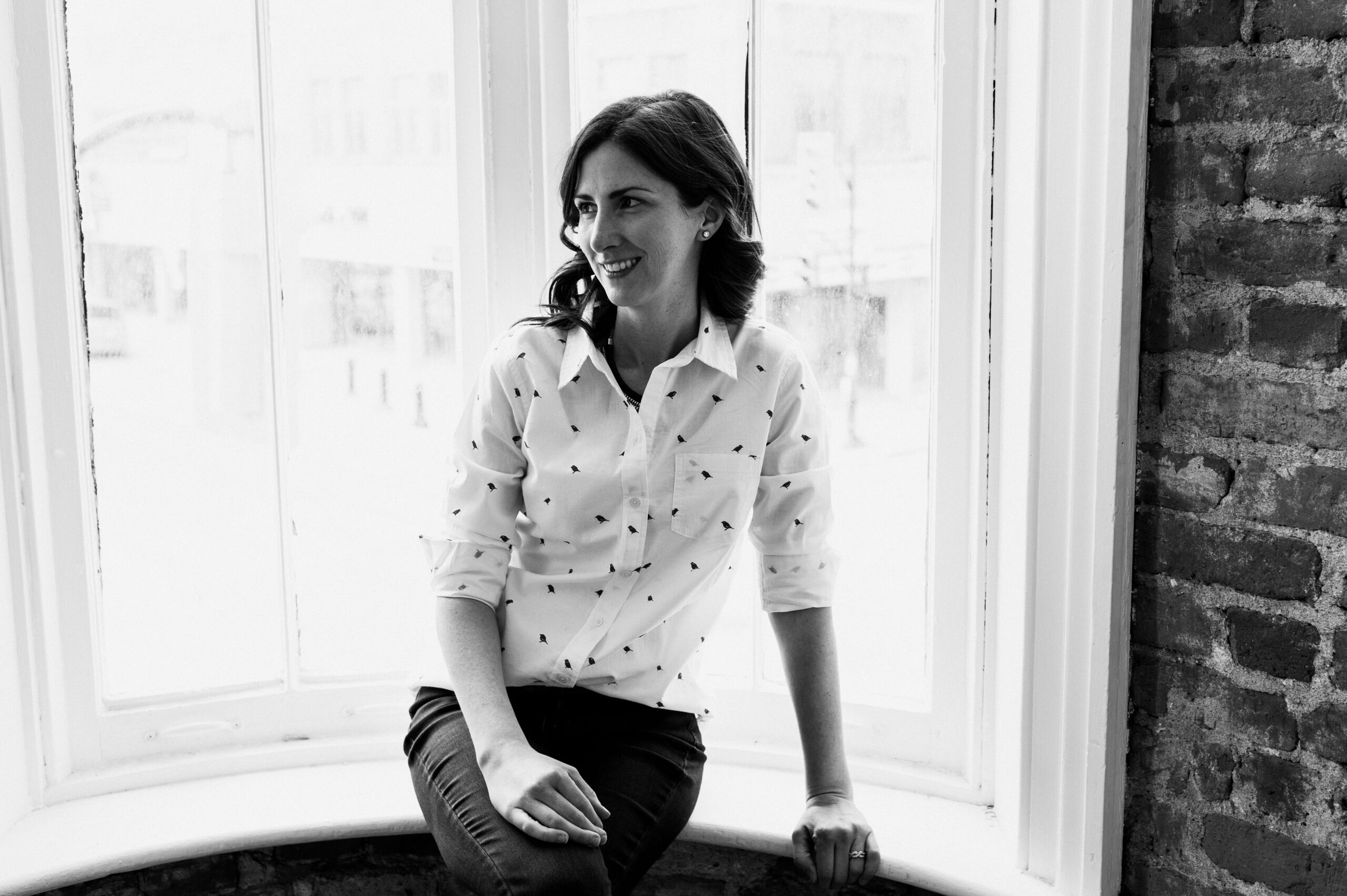 black & white photograph of Stephanie sitting near a window
