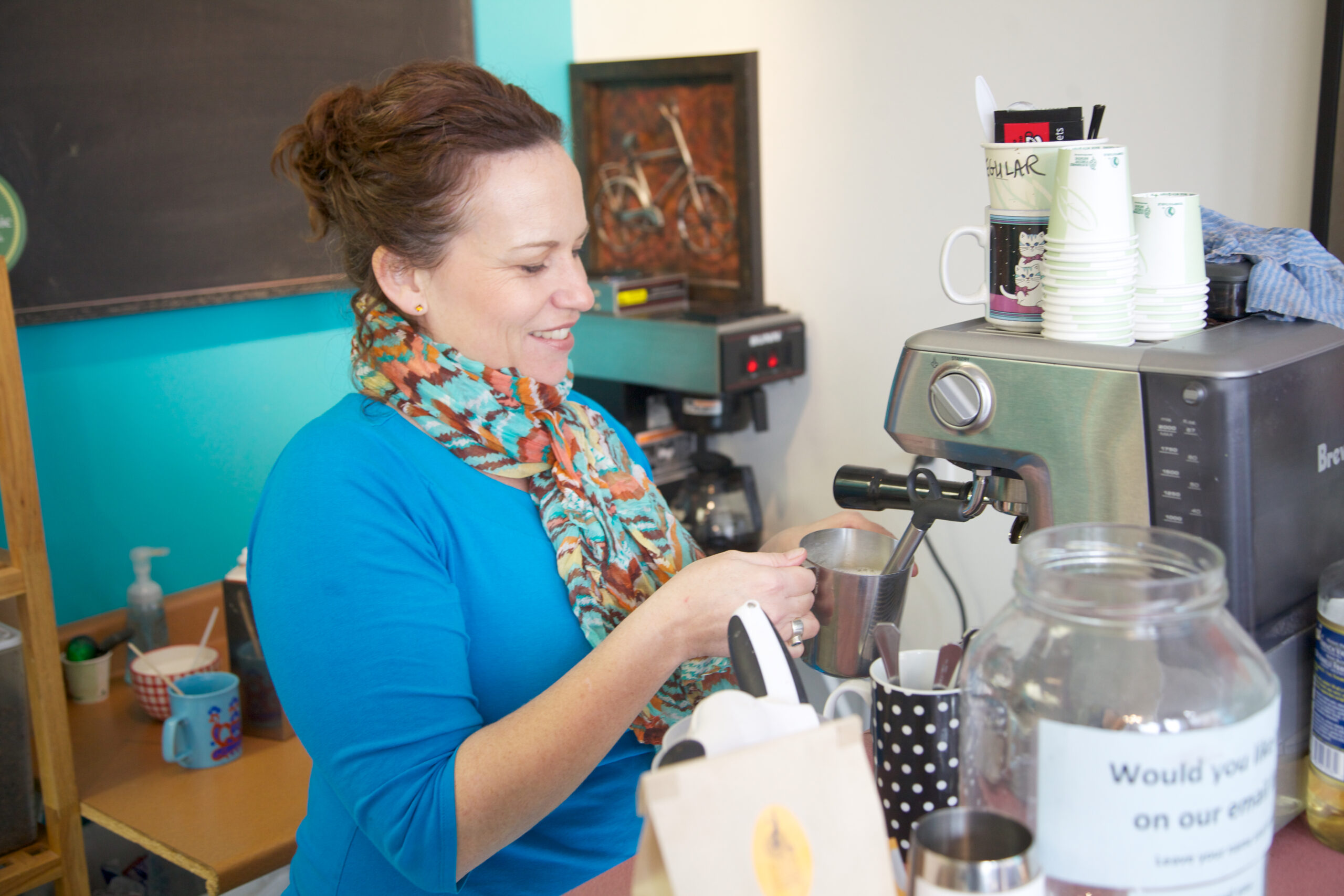 a woman making coffee using coffee machine