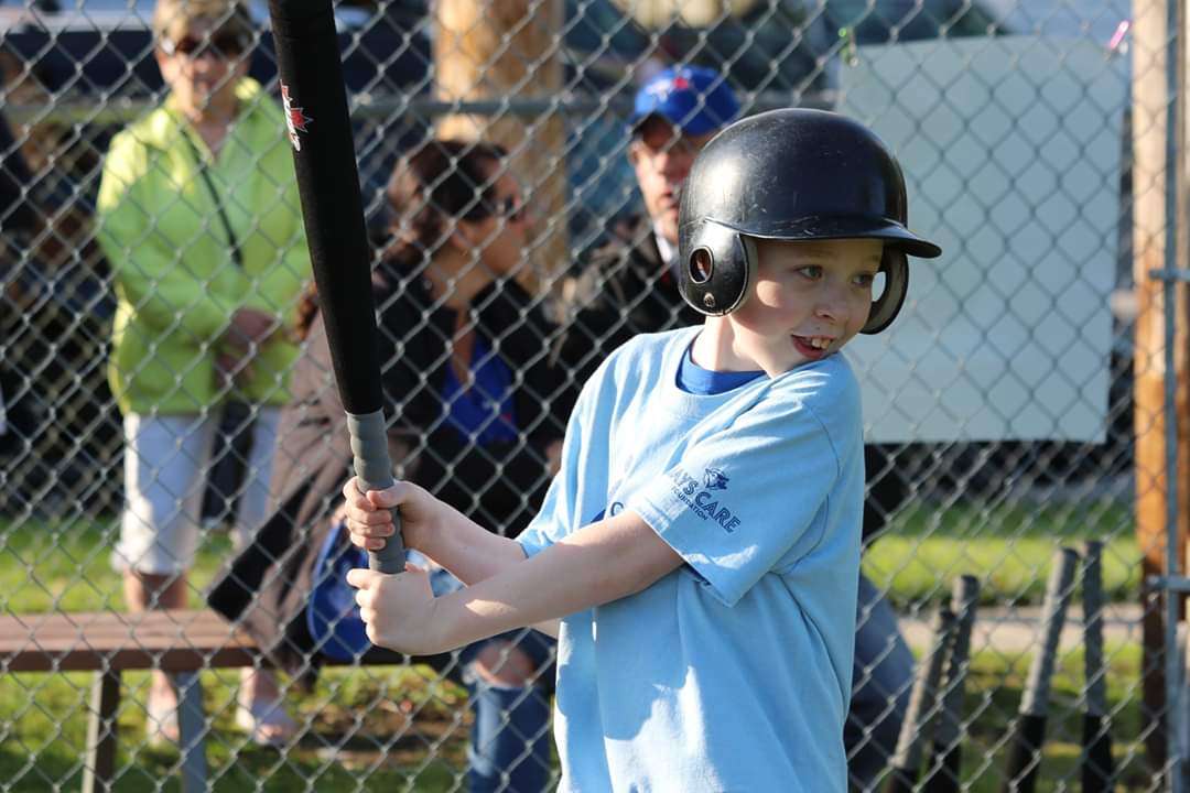 a boy swinging the baseball bat in air