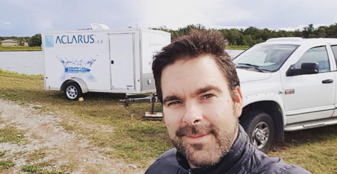 man taking selfie with Aclarus van in the background
