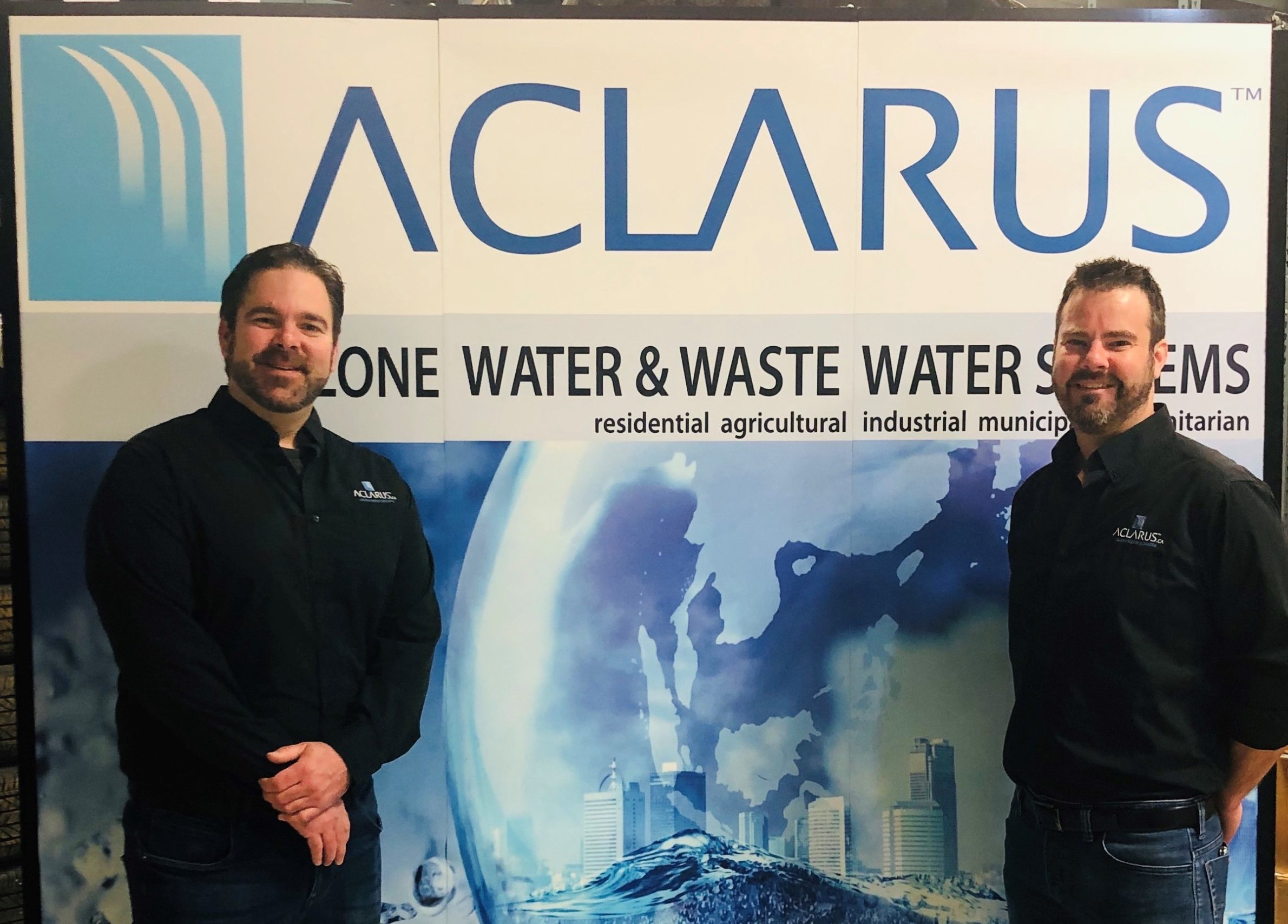 two men in front of banner reading Aclarus