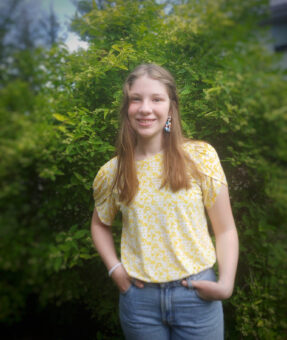 a girl in yellow top with hands in pocket