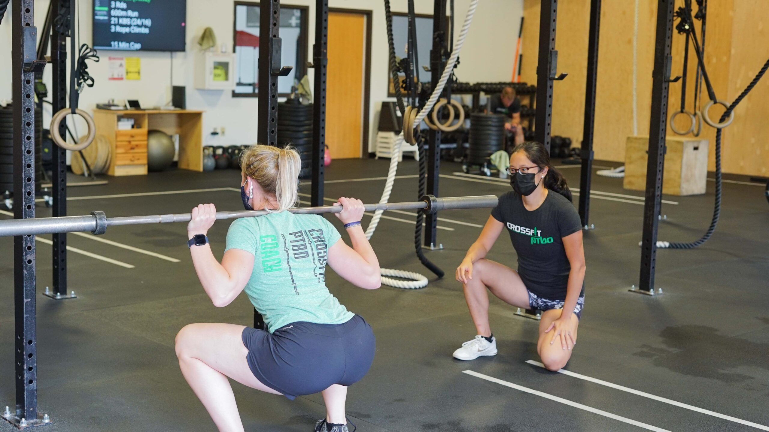 a woman trainer training another woman in the gym