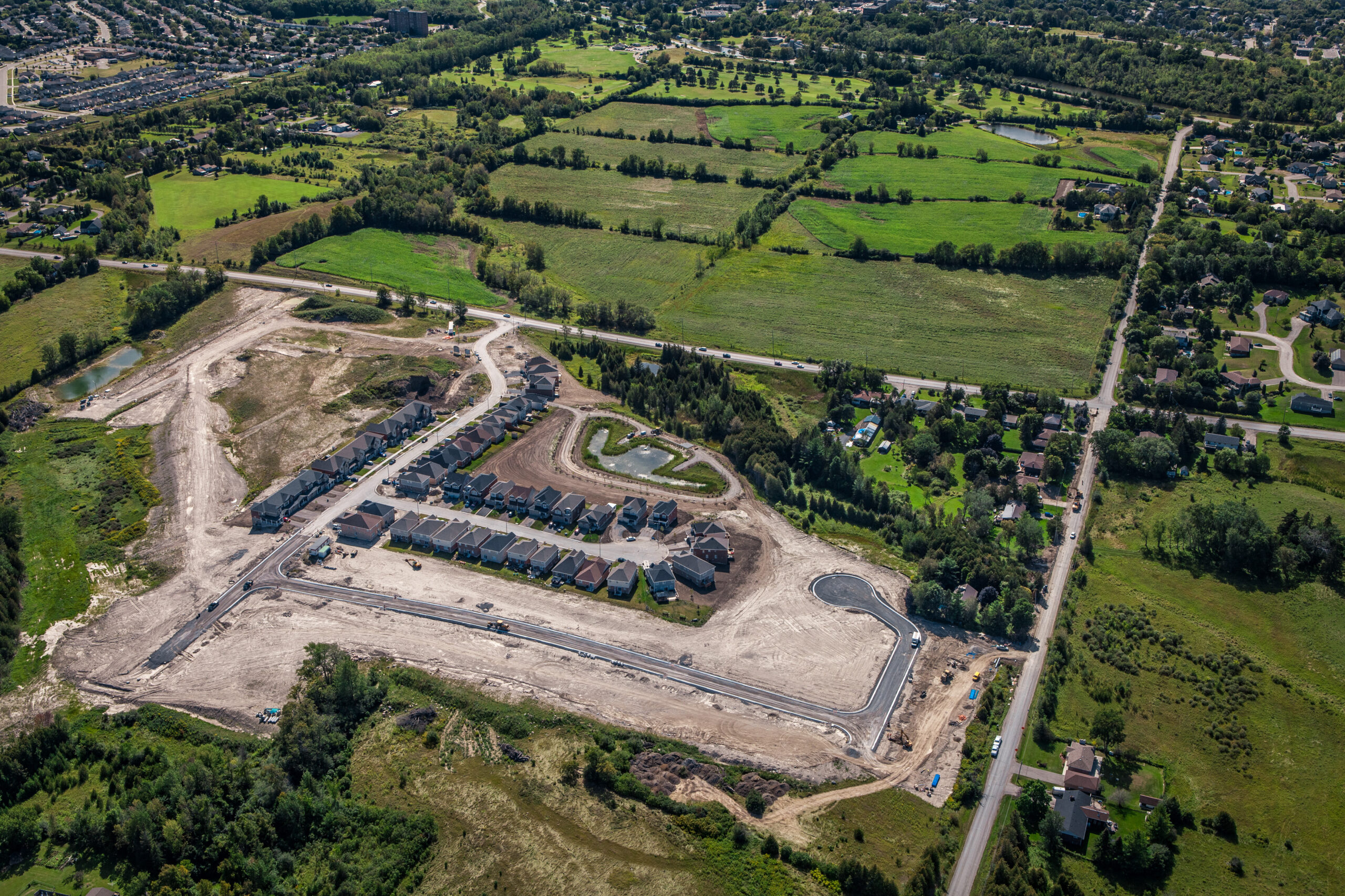 aerial view of a subdivision under construction surrounded by greenspace
