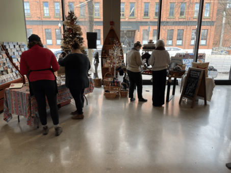 people browsing gift items at vendor tables inside visitor centre at holiday pop up