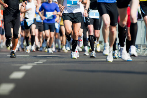 picture of group of runners running in a marathon on a paved road