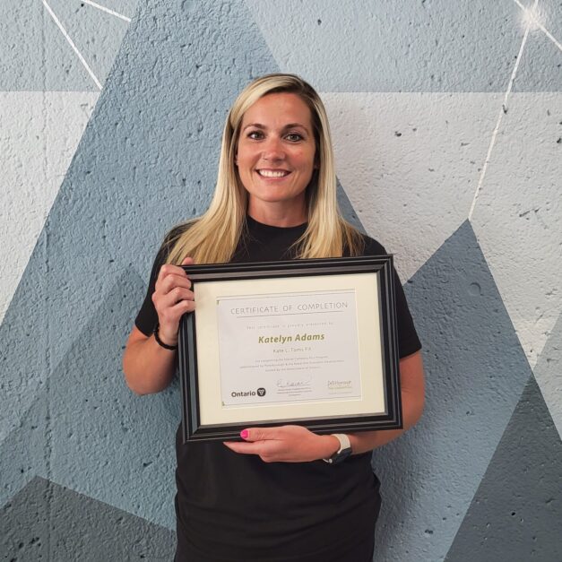 Kate Adams standing in front of a geometric background holding a Starter Company Plus certificate