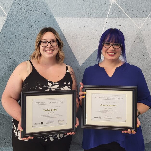Tavlyn Evans and Crystal Walker standing in front of a geometric background holding a Starter Company Plus certificate