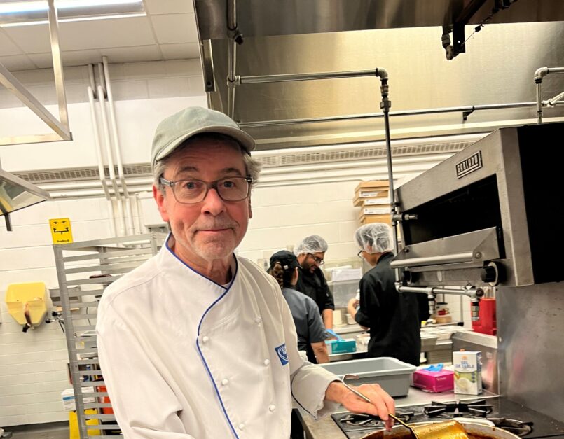 Gary Hoyer wearing a chef's uniform in an industrial kitchen